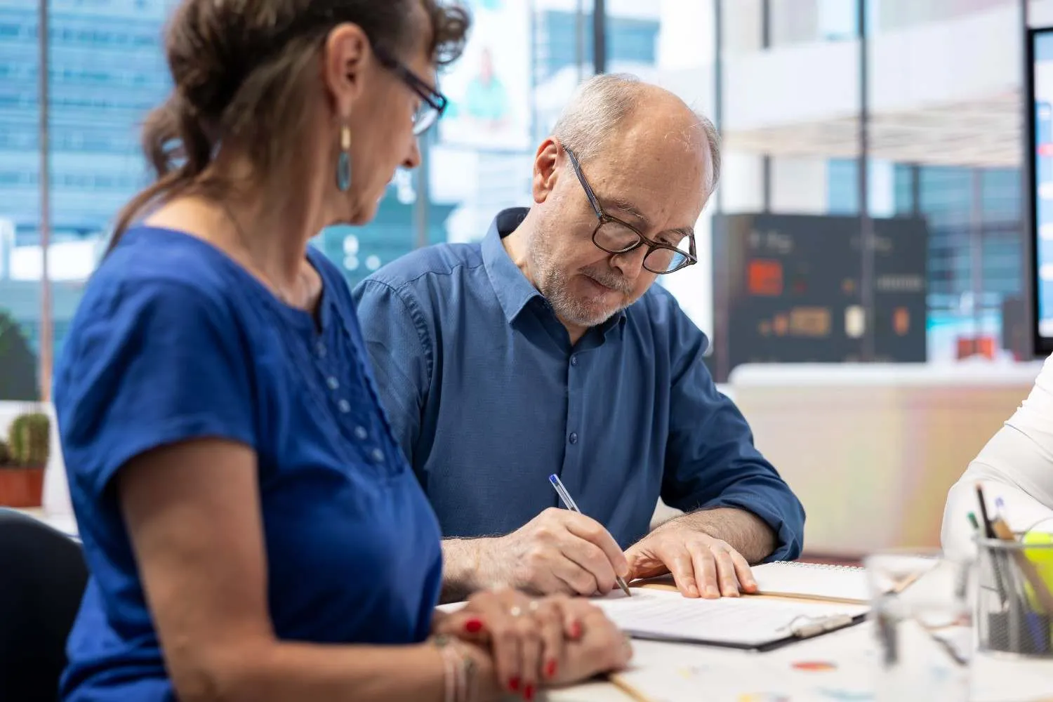 A Medicare adviser talking through plan paperwork with an older couple